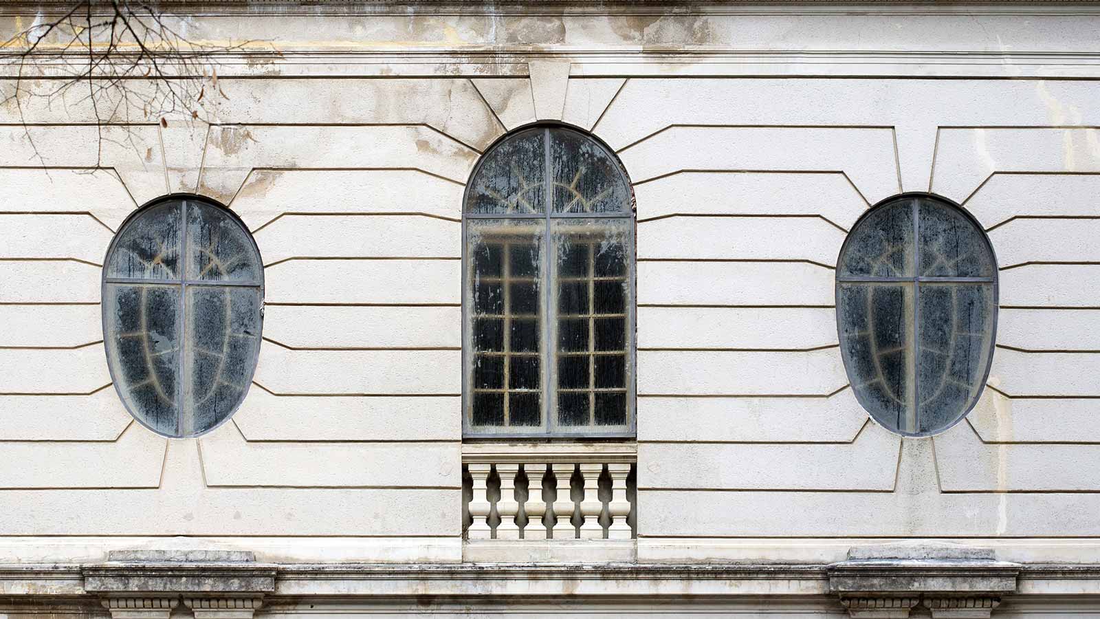 Fenêtres ovoïdes et fenêtre en forme d'arche de la façade de l'Auberge des Dauphins.
