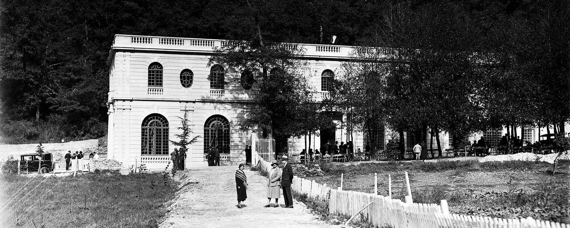 Photo d'archives de l'inauguration de l'Auberge des Dauphins montrant le bâtiment et des personnes.